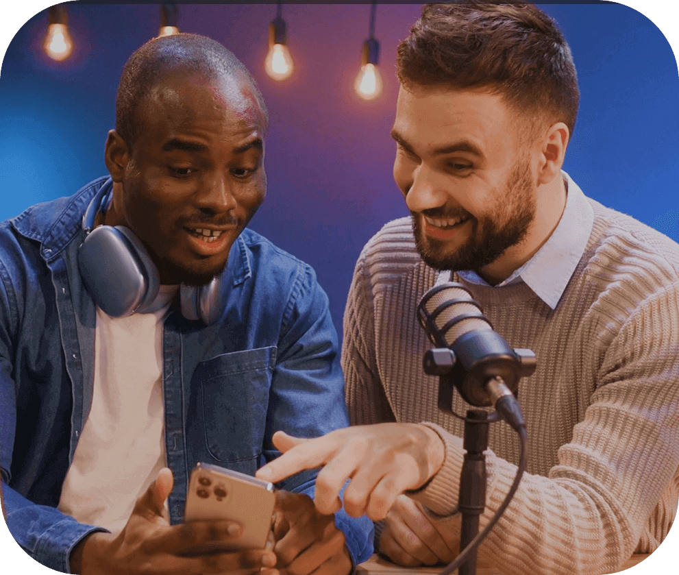 Two men smiling and looking at phone.